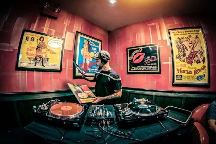 Van Paugam selecting records behind two turntables at the Logan Theatre in Chicago